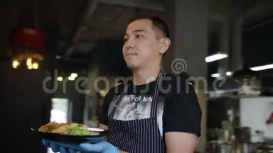 迷人的亚洲厨师正拿着一个盘子和虾在一家餐厅，跟踪弧线射击360度